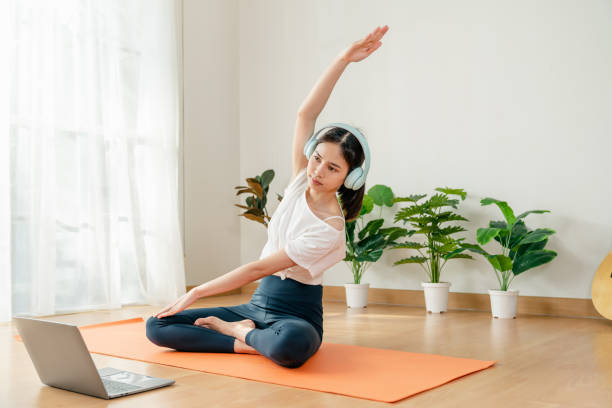istock woman doing exercise yoga plank and watching online tutorials on laptop. 2158816545