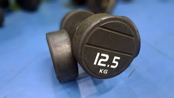 istock 12.5 kg dumbbell resting on blue gym floor 2158818063