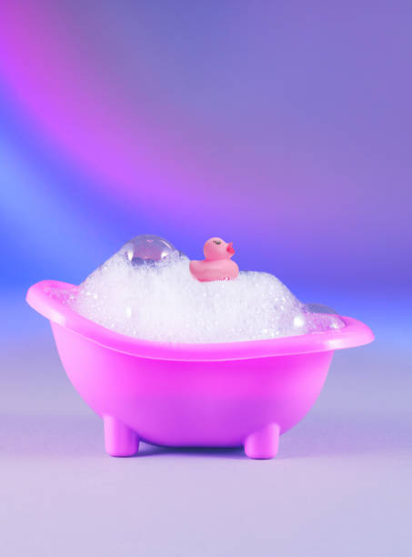 istock Cute pink duck in foamy pink tub, vibrant gradient backdrop 2158821215