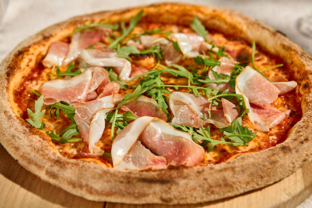 istock Pizza with Parma Ham and Arugula in Summer Sunlight and Shadows 2158824613