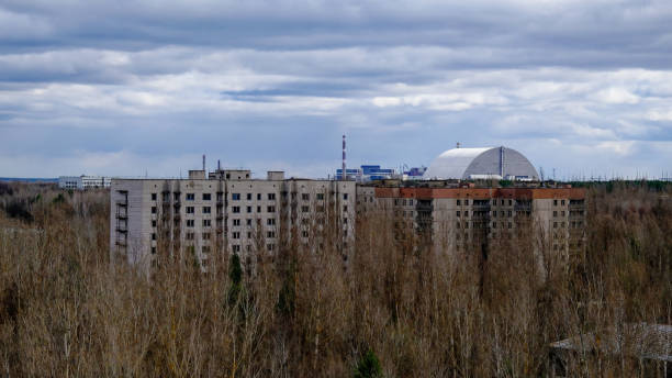 istock A large building with many windows is surrounded by bare trees, under a cloudy sky. 2158825746