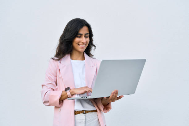 istock Focused young middle eastern Israel businesswoman using laptop pc online application for work isolated on white wall. Indian or arabic woman in business suit holding computer, doing data base research 2158826916