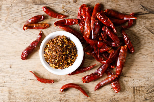istock Dried red chilie and ground chilli on wooden table. 2158827995