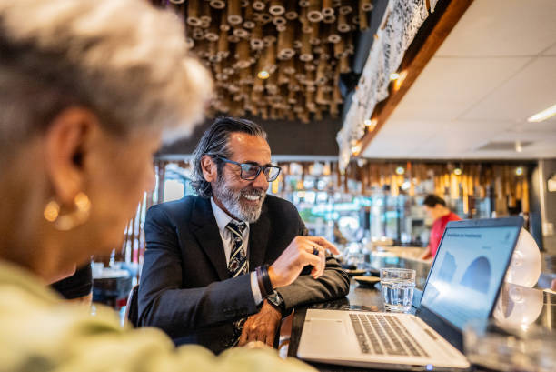 istock Businessman using laptop with coworker on a japanese restaurant 2158831241