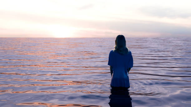 Young woman watching the sun set over the water she is standing in.  Image is a 3d render.