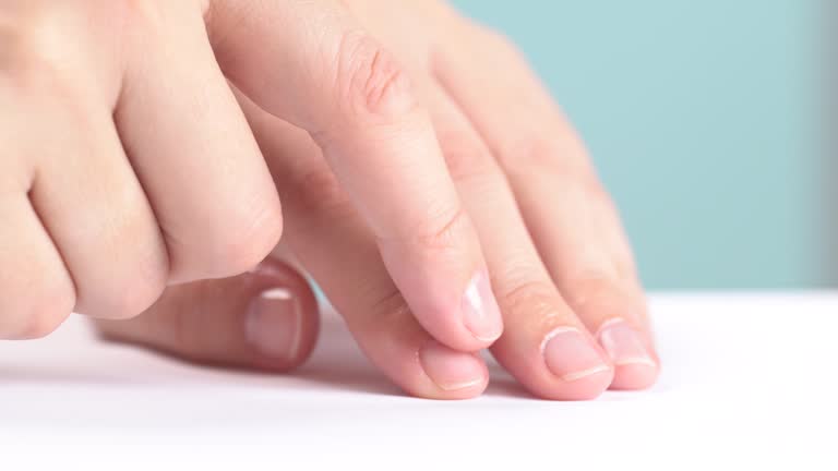 Moisturizing serum or oil for cuticles. The woman cares for hands and nails, close up. Woman applying oil from droper to nails, macro. Healthy nails concept. Hands massage with oil