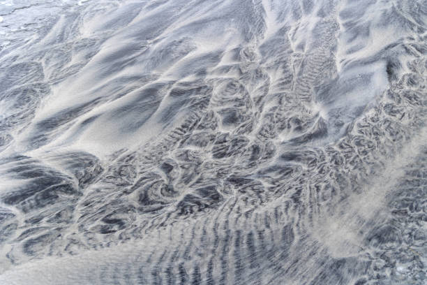 istock Sand patterns carved through running trickles - background and testure 2158833627