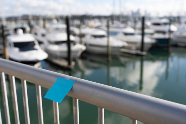 istock A blue sticky note is attached to a railing overlooking a marina filled with boats 2158834694