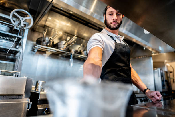 istock Young chef preparing food at commercial kitchen 2158834978