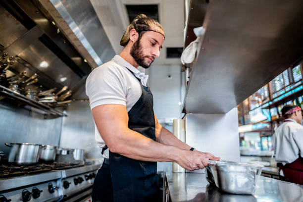 istock Young chef preparing food at commercial kitchen 2158834979