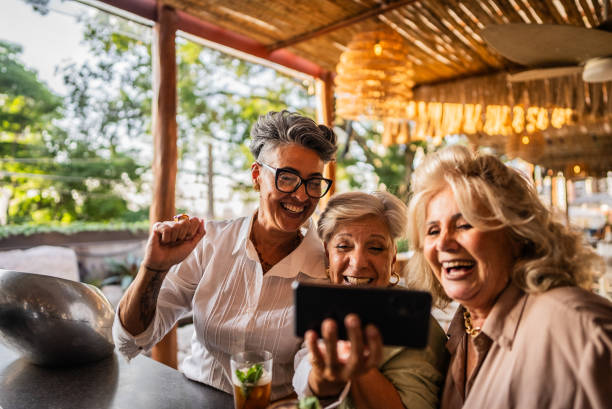 istock Female friends using mobile phone at bar or restaurant 2158834980