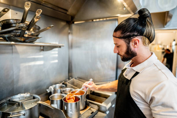 istock Young chef making food on commercial kitchen stove 2158834987