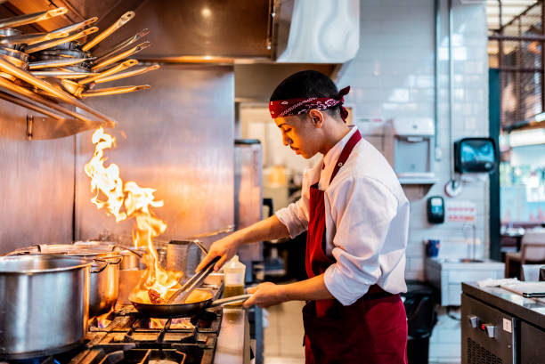 istock Young chef making food on commercial kitchen stove 2158834998