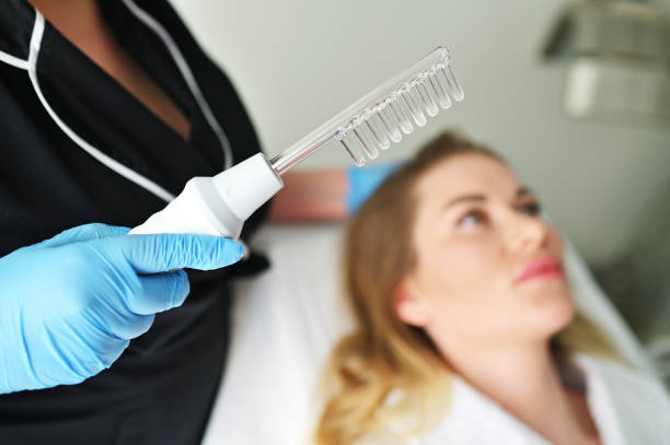 istock dermatologist trichologist performs the procedure with a darsonval device to improve the condition and quality of the patient's hair. 2158835258