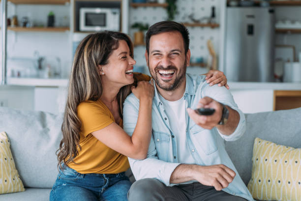istock Cute young couple cuddling while watching tv. 2158835311