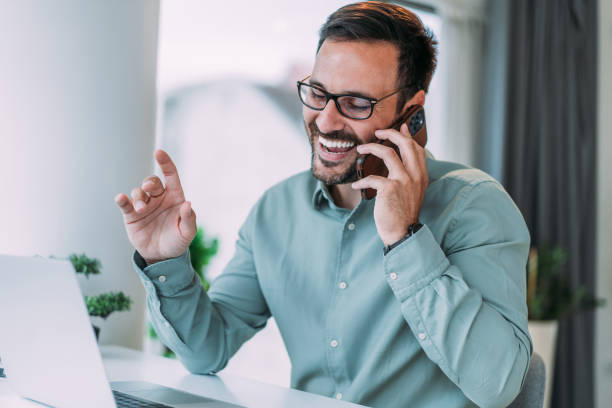 istock Businessman working on laptop and talking on cellphone. 2158835313
