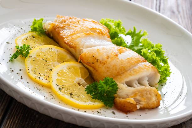 istock Fried halibut steak and fresh vegetables on wooden table 2158836806