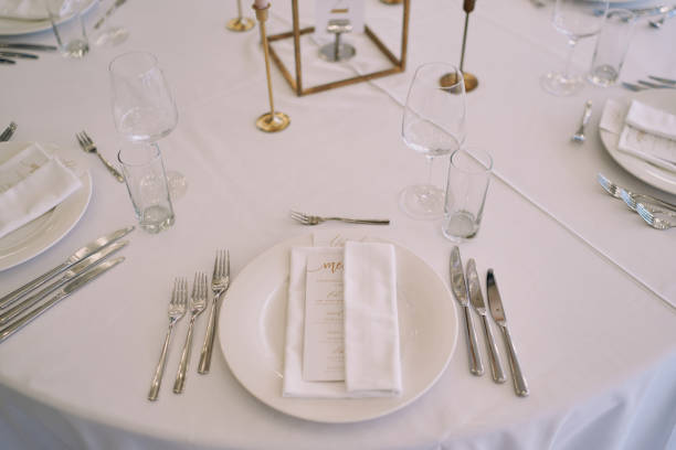 istock Invitation with a festive menu wrapped in a napkin lies on a plate on a set table 2158839372
