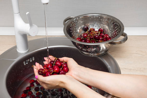 istock housewife washes cherries in the kitchen sink. 2158844536