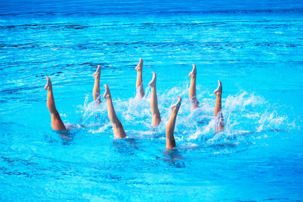 istock Artistic swimmers team performing synchronized choreographed routine in the swimming pool 2158845298