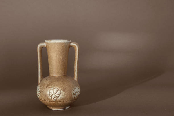 istock small clay retro jar on a brown background 2158845326