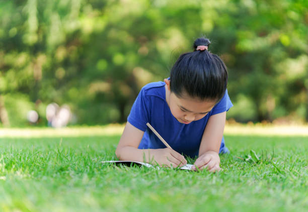 Little Girl Writing on Lawn
