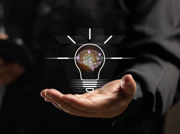 istock Businessman holds a light bulb with an artificial intelligence engine on his hand. artificial intelligence technology that will help make working via mobile phones easier and more convenient. 2158847636