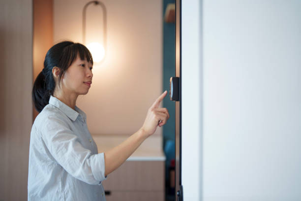 istock An Asian woman at home adjusts the temperature using a smart thermostat, exemplifying smart home concepts. 2158847900
