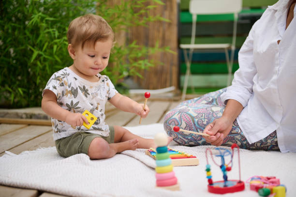 istock Toddler playing with educational toys outdoors with parent 2158848142
