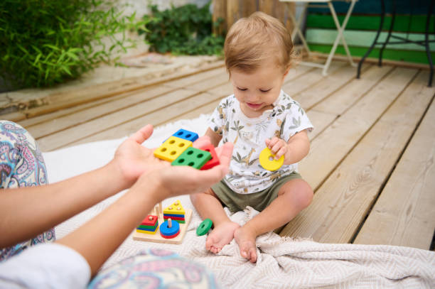 istock Toddler playing with educational toy blocks outdoors 2158848976