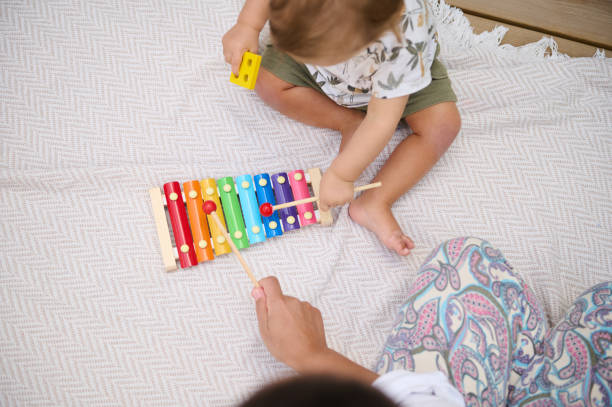istock Mother and child playing xylophone together outdoors on blanket 2158849352