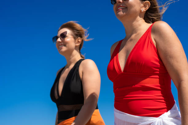 Beautiful women walking on sunny beach