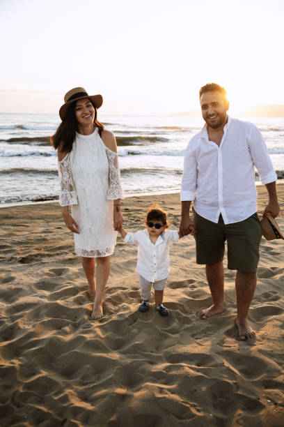 istock Family Walking on the Beach at Sunset 2158853859