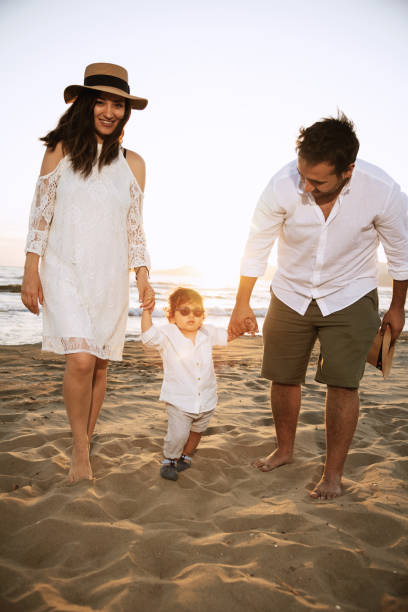 istock Family Walking on the Beach at Sunset 2158853860