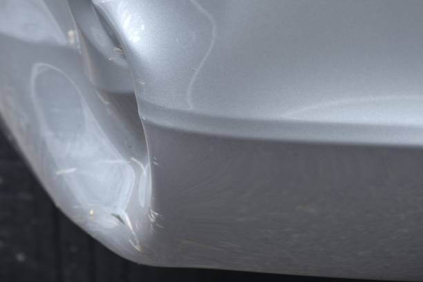 istock pound and scratch from accident on bumper of silver color car background and texture 2158854107