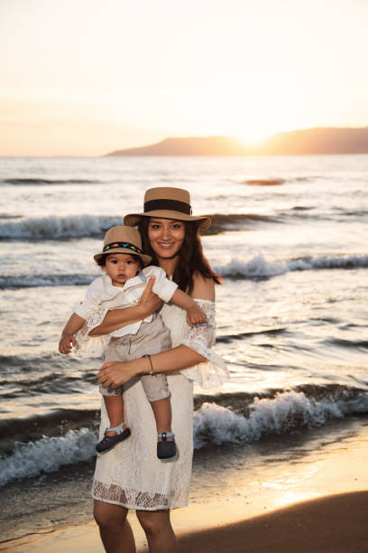 istock Mother and Child Enjoying Sunset on the Beach 2158854140