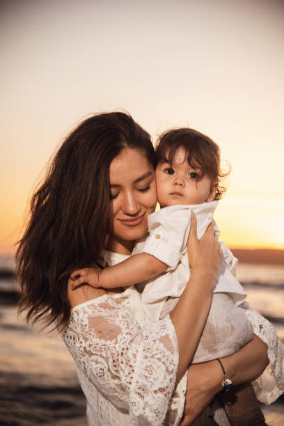 istock Mother and Child Enjoying Sunset on the Beach 2158854143