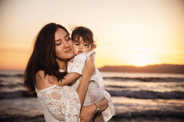 istock Mother and Child Enjoying Sunset on the Beach 2158854144