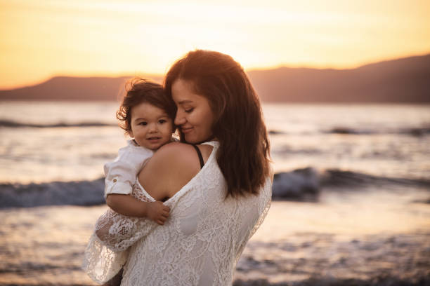 istock Mother and Child Enjoying Sunset on the Beach 2158854145