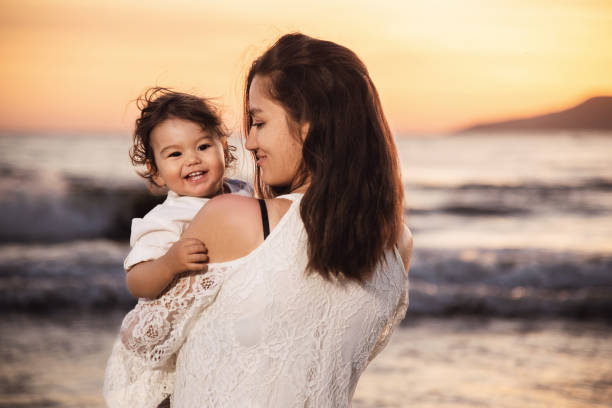 istock Mother and Child Enjoying Sunset on the Beach 2158854157