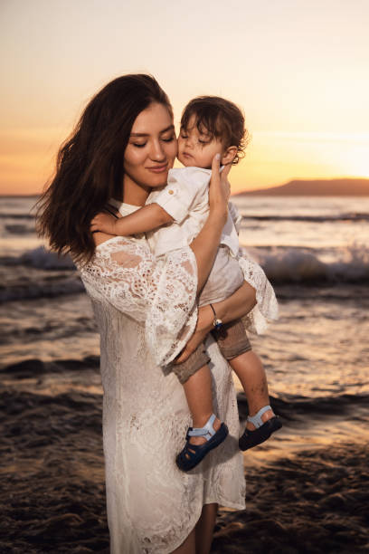 istock Mother and Child Enjoying Sunset on the Beach 2158854167