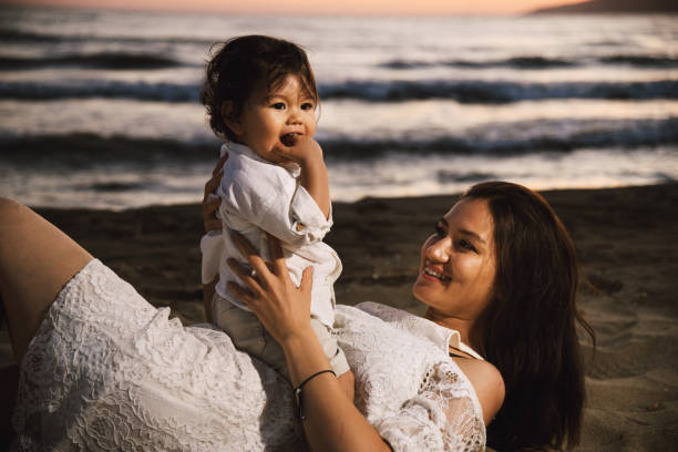 istock Mother and Child Enjoying Beach Sunset 2158854171