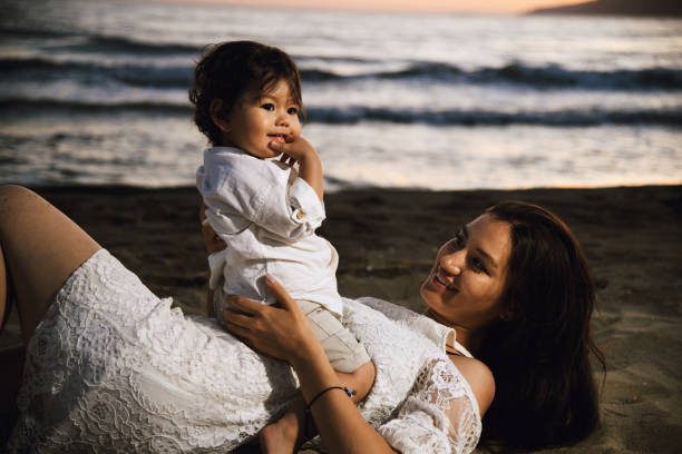 istock Mother and Child Enjoying Beach Sunset 2158854178