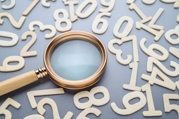 istock A magnifying glass and random wooden numbers 2158854604