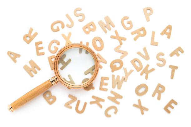 istock Magnifying glass and scattered English alphabets 2158854618
