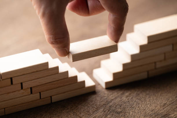 Fill the gap between the separated bridge Closeup hand fill the gap between the separated bridge built by the wooden toy, a solution to solve the gap problem separation stock pictures, royalty-free photos & images