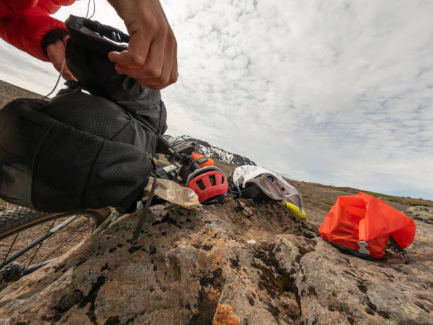istock Man Packing Camping Gear on Rocky Terrain 2158854875