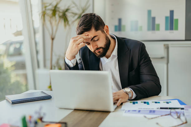 istock Businessman feeling stressed while working on laptop in office 2158855688