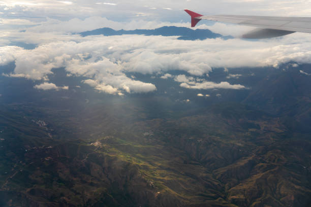 View of the wing of an airplane with a mountain range in the evening light in the background. Colombia.