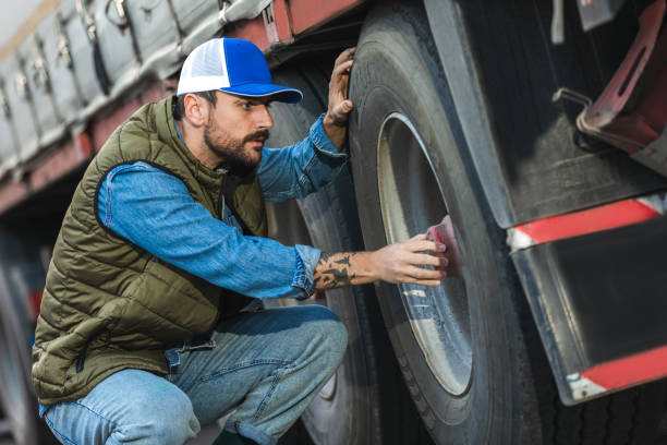istock Young handsome truck driver checking if everything is good with his truck. 2158856669